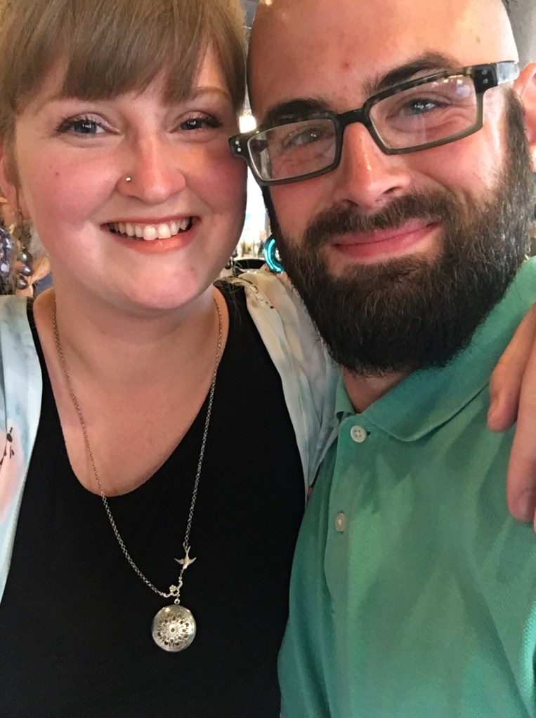 Joe and Sarah posed together, dressed up and smiling.